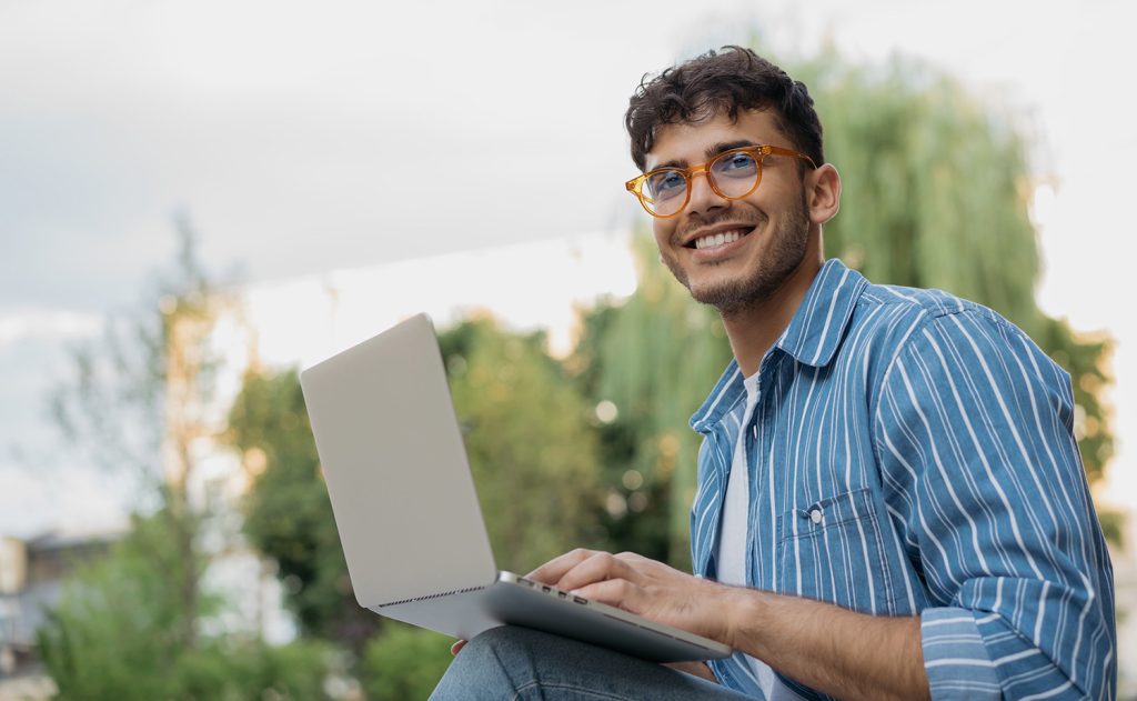 Student sitting outside with laptop