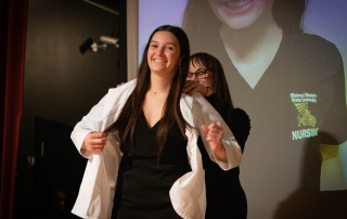 A first-semester nursing student receives a white coat during the Missouri Western Lighting of the Lamp White Coat Ceremony on March 3, 2023.
