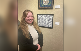 Kylee Derr with her artwork at the exhibition's opening reception April 21.