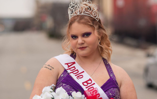 breanna hess wearing apple blossom queen sash, holding flowers and wearing a tiara