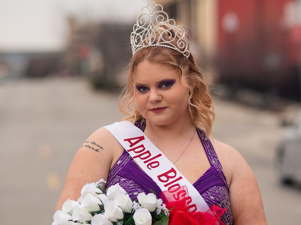 breanna hess wearing apple blossom queen sash, holding flowers and wearing a tiara