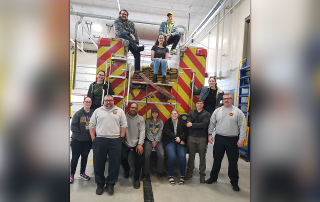 missouri western students pose with fire fighters on the back of a fire truck