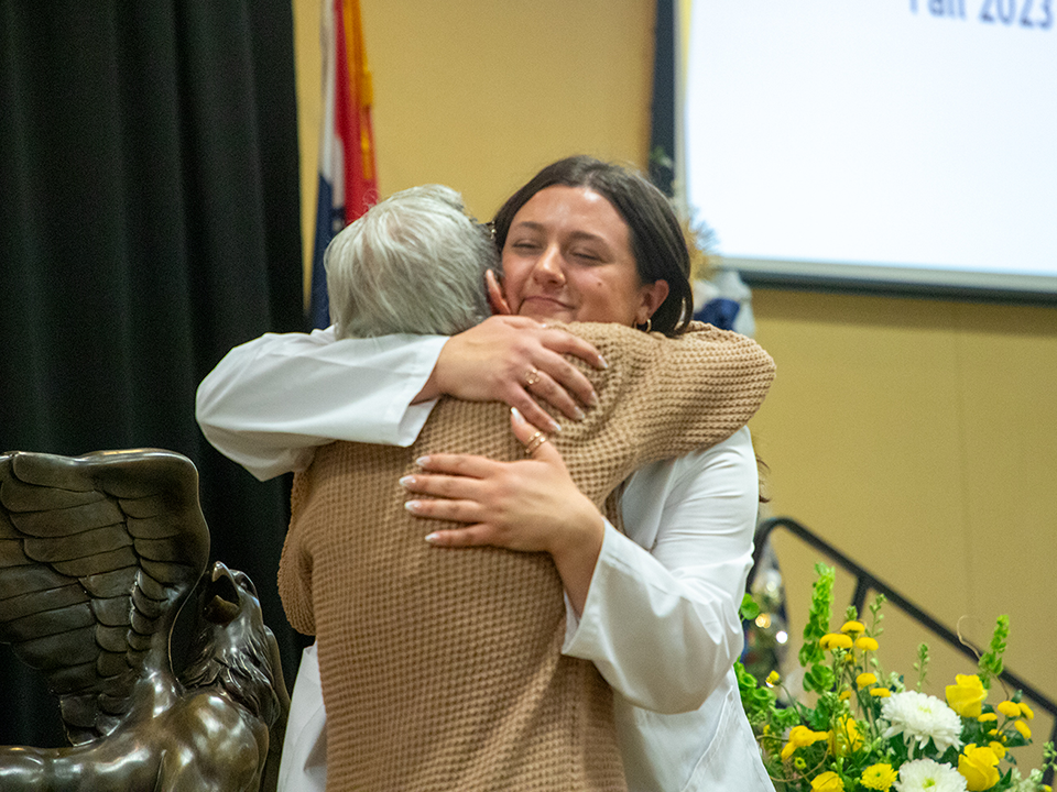 nursing student hugs family member at pinning ceremony