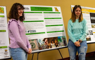 two students posing with their poster at the applied learning showcase