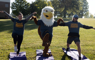 two individuals do yoga with max the griffon during the griffon 360 family walk during family day 2022