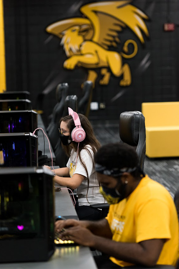 student sitting at a computer in the esports arena