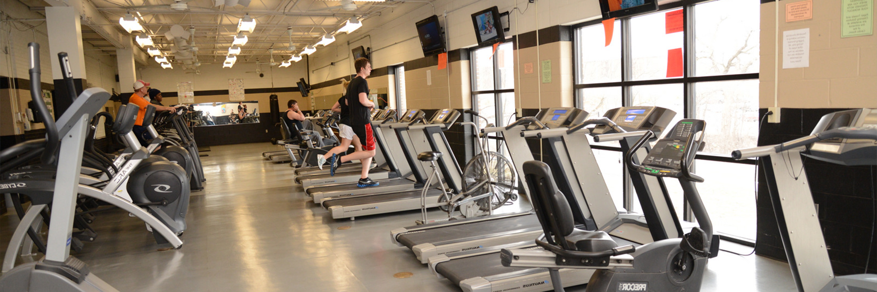 four students on treadmills in the campus gym