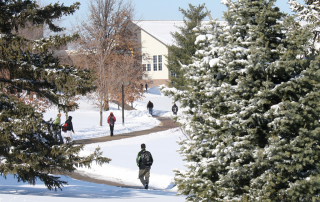 students walking across campus in the snow