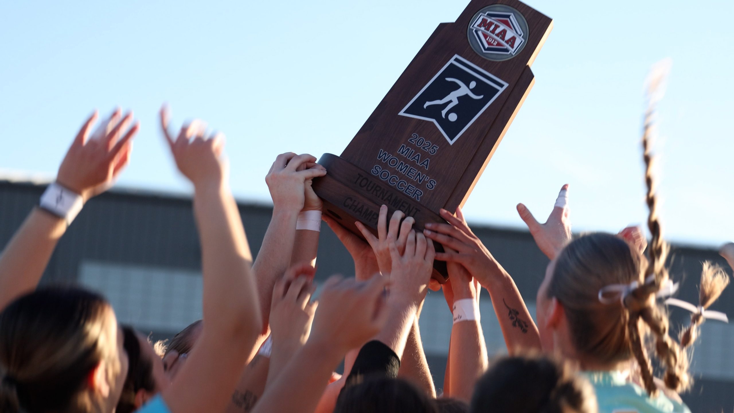 The MoWest women's soccer team holds the MIAA trophy high
