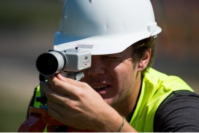 An instructor and two students work on a piece of equipment