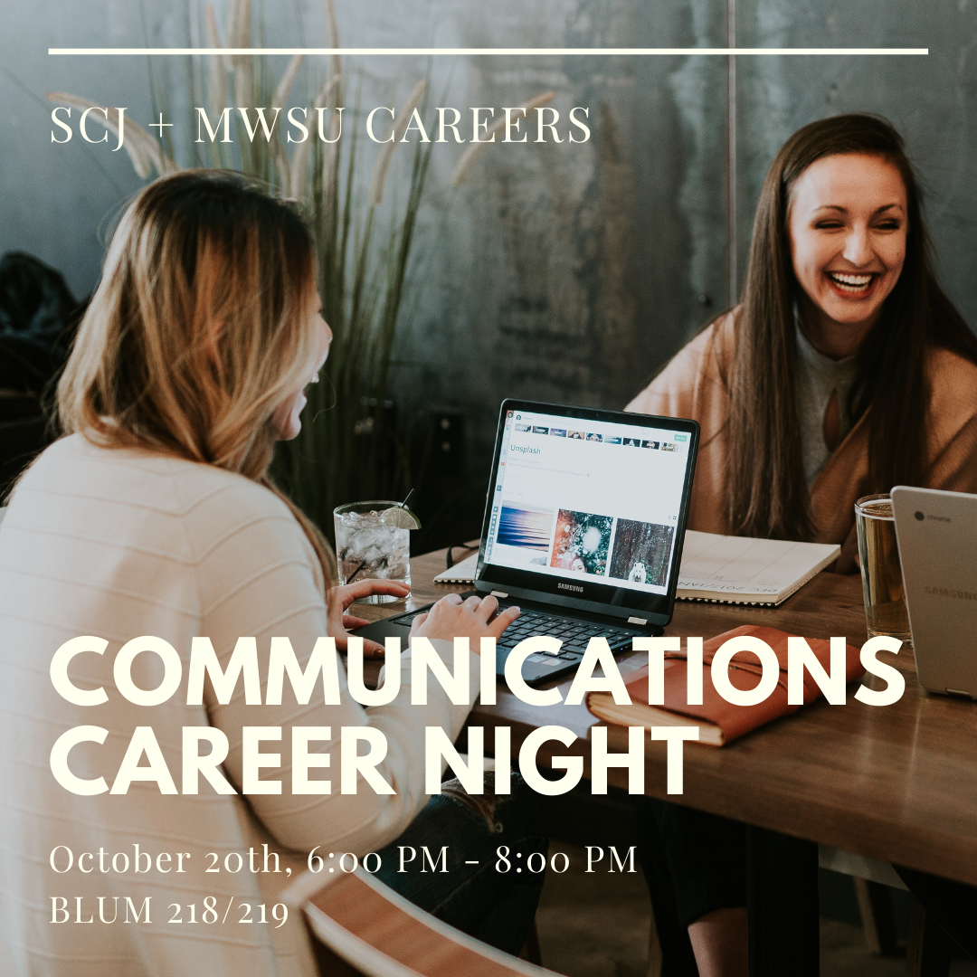 Students at a table with computers laughing