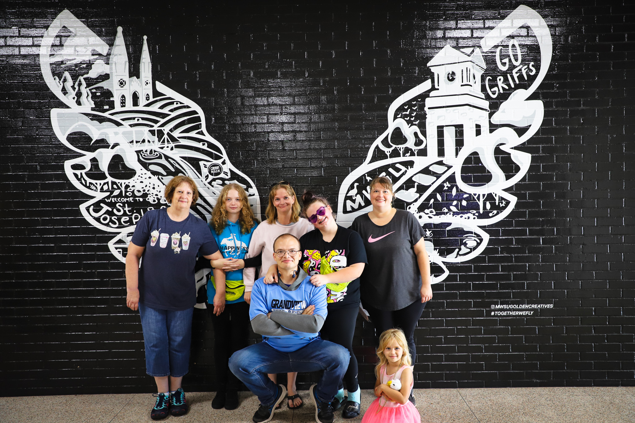 family poses in front of Griffon wings in Blum Union