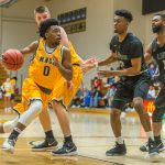 Bryan Hudson runs in for a layup while his teammate blocks the Lion's defensive players