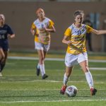 Senior Sydney Cluck heads down the field to attempt a goal against the opposing team.