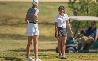 Steffanie Yabut talks with a competitor before she tee's up for her shot